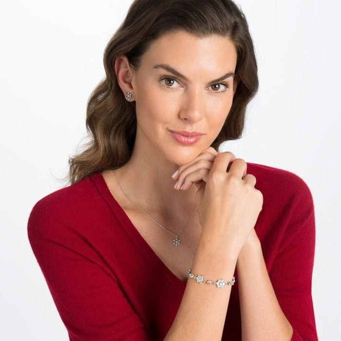 Model wearing a Brighton silver-plated pendant necklace with star motif and coordinating Brighton stud earrings and bracelet