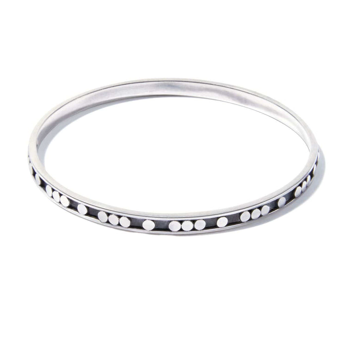 Brighton bangle bracelet in sterling silver with beaded dot detailing along oxidized channel on a white background