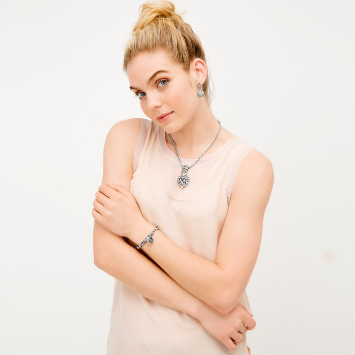 Model wearing a Brighton silver-plated heart pendant necklace with coordinating Brighton accessories featuring filigree scroll detailing