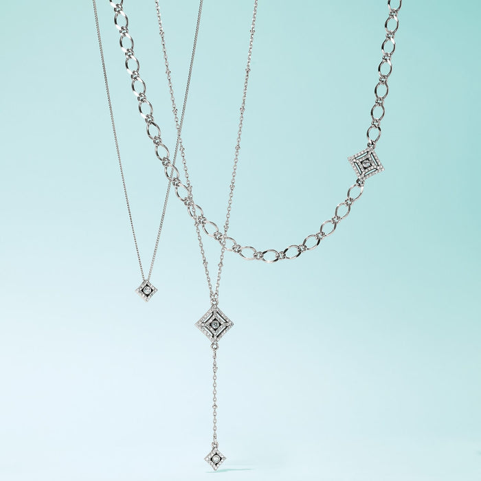 Brighton layered necklaces with silver-plated diamond-shaped pendants featuring crystal accents and varied chain styles on a white background