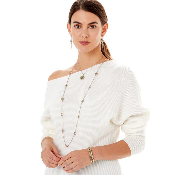 Model wearing a Brighton two-tone long station necklace with circular medallions and coordinating Brighton accessories