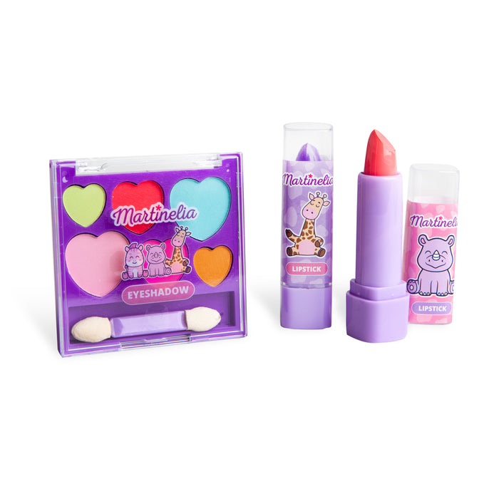 The Martinelia My Best Friends Makeup Set by Martinelia includes a heart and circle-shaped purple eyeshadow palette, two animal-themed lipsticks, and a double-ended applicator—all with playful cartoon designs for imaginative pretend play.