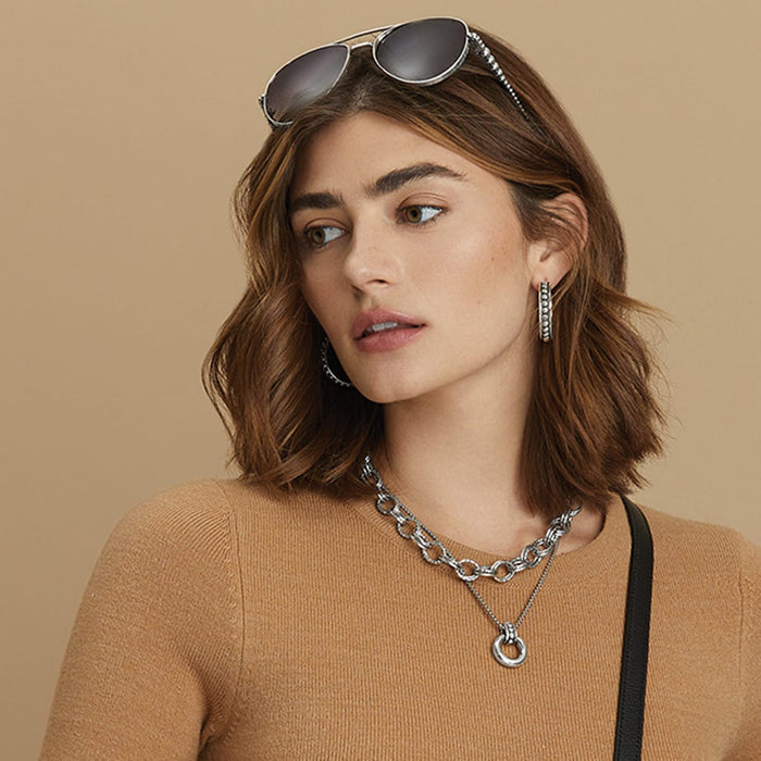 Model wearing a Brighton silver-plated layered chain link necklace with circular pendant and coordinating Brighton accessories