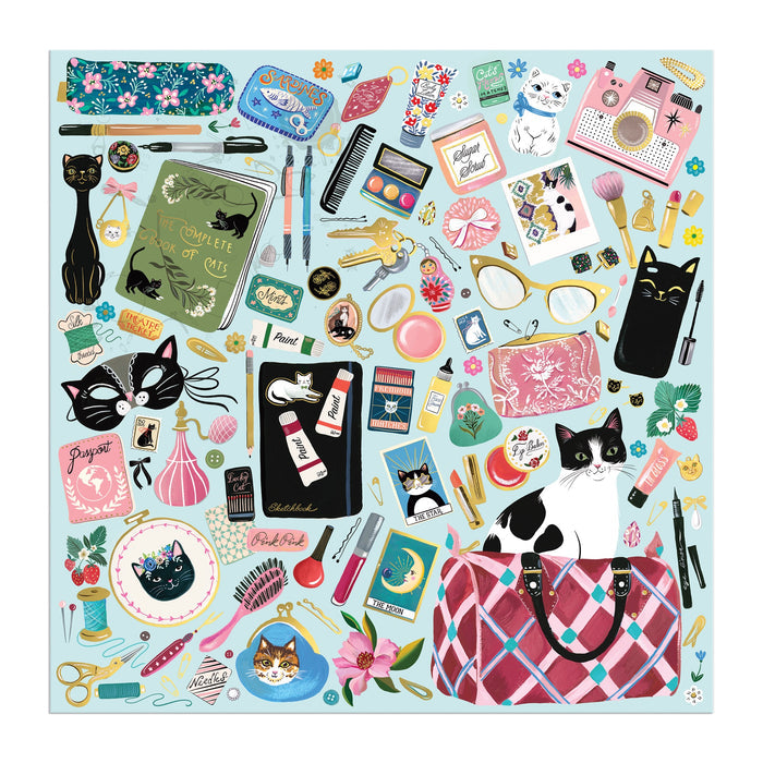 The Purrfect Accessories 500 Piece Foil Puzzle by Christine De Carvalho features a vibrant collage of cat-themed items—books, glasses, mugs, plants, and more—on a light blue background, perfect for feline and puzzle lovers.
