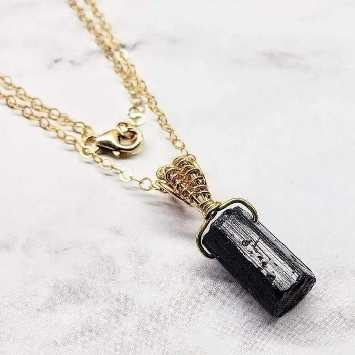 Wire Wrapped Raw Black Tourmaline Gemstone Necklace on a delicate gold chain with a unique wire wrap design.