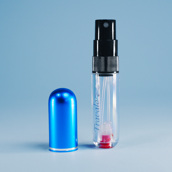 Clear spray bottle with black nozzle and blue cap on a light blue background