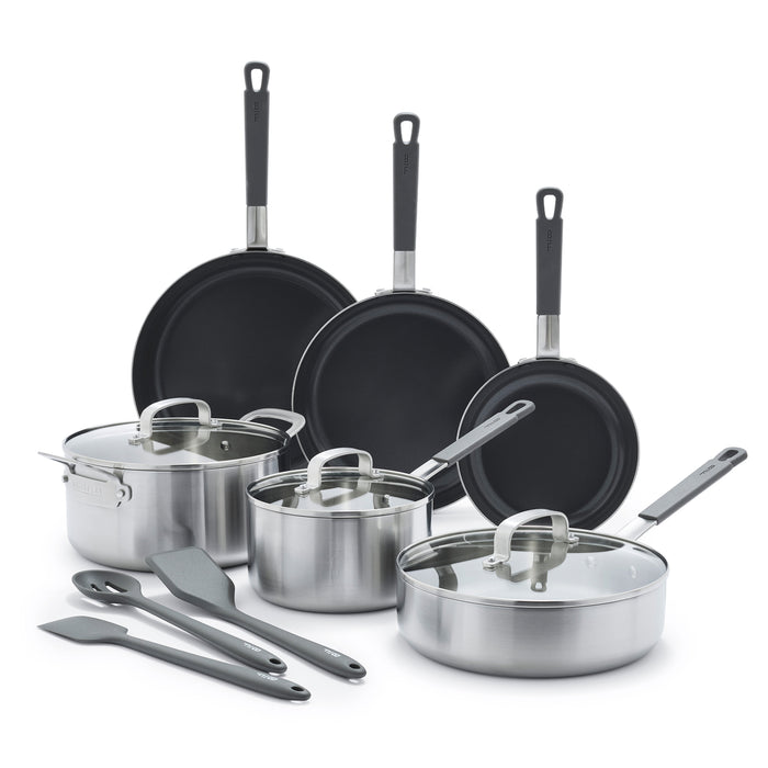 12-piece stainless steel cookware set with lids and black utensils on a white background.