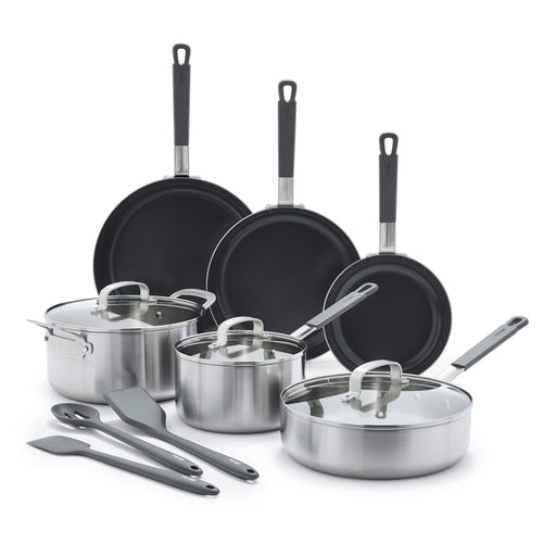 12-piece stainless steel cookware set with lids and black utensils on a white background.