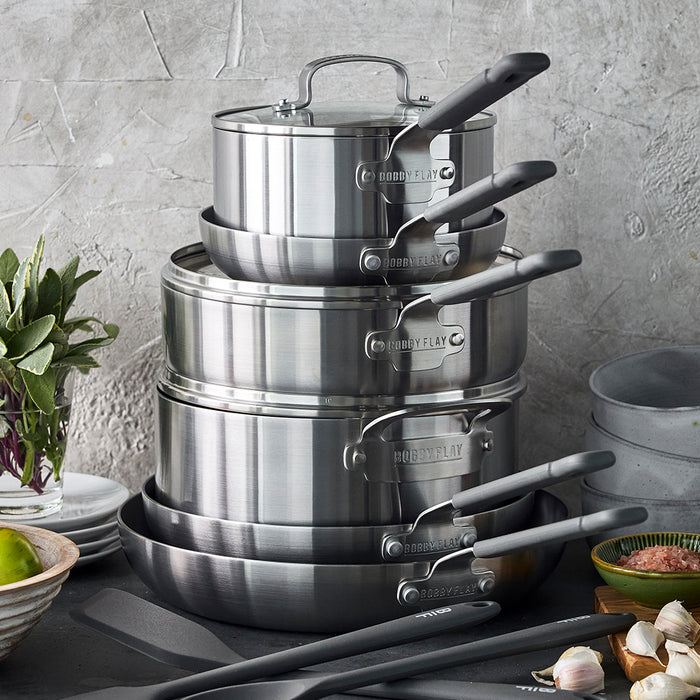12-piece cookware set with stainless steel and nonstick pots and pans arranged on a kitchen counter.