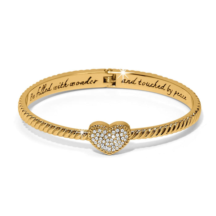 Brighton bangle bracelet in gold-tone with twisted rope design, crystal pavé heart, and engraved inscription on a white background