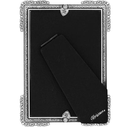 Brighton picture frame shown from the back with silver-plated ornate scroll border and black velvet easel stand on a white background