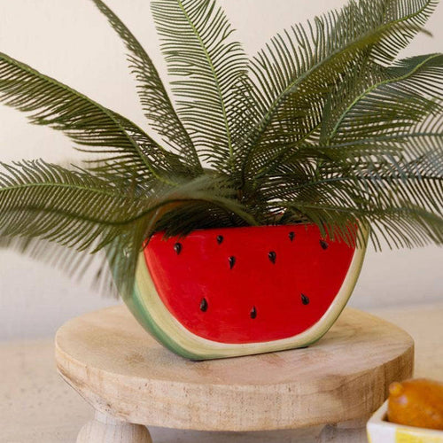 Decorative item with a watermelon-shaped planter on a wooden stand.