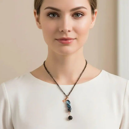 Child Abuse Awareness Agate Necklace With Lava Rock Bead worn by a woman, featuring blue agate beads and a copper spiral pendant.