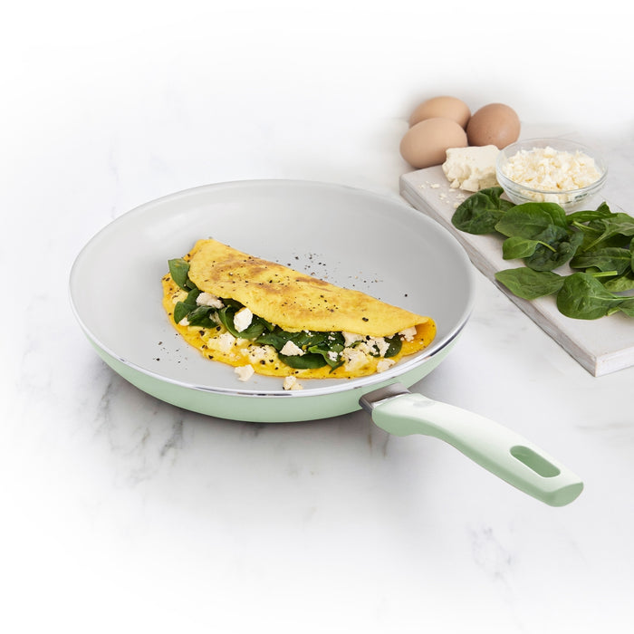 Omelet with spinach and cheese in a Dover ceramic nonstick 10-inch frypan, with eggs, cheese, and spinach beside it.