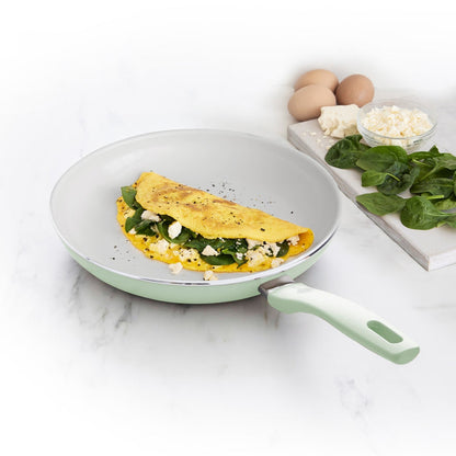 Omelet with spinach and cheese in a Dover ceramic nonstick 10-inch frypan, with eggs, cheese, and spinach beside it.