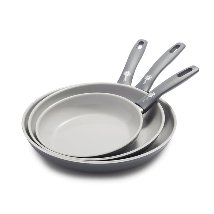 Set of three ceramic nonstick frypans in different sizes, stacked with handles overlapping.