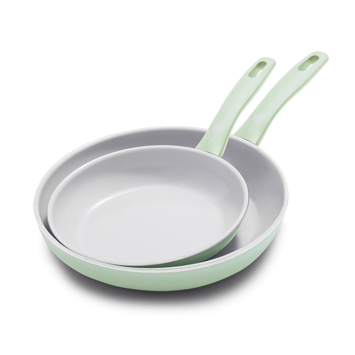 Set of two pastel green ceramic frypans, 8-inch and 10-inch, stacked with overlapping handles on a white background.