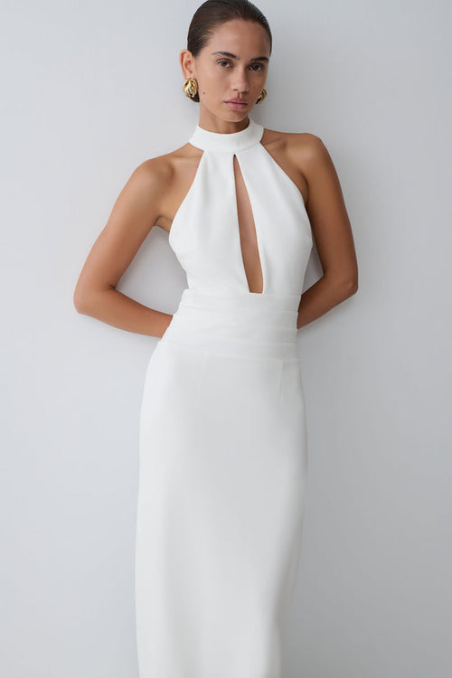 Woman wearing a white halter neck dress.