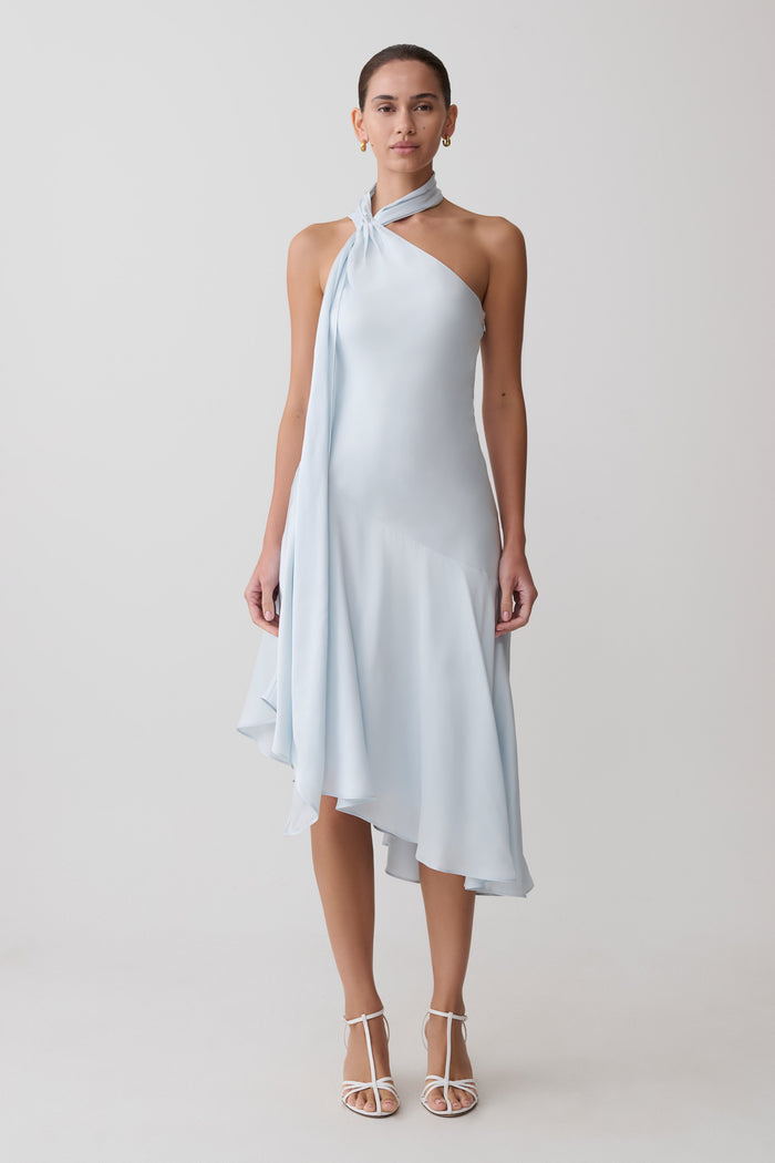 Woman wearing a light blue halter neck dress on a white background