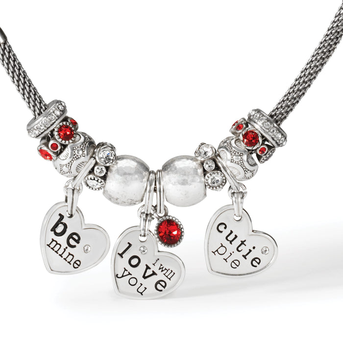 Close-up of Brighton silver-plated charm necklace with be mine, love you, and cutie pie heart charms