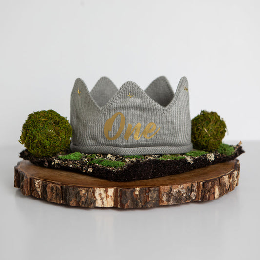 Gray knitted crown with One in gold lettering and gold accents