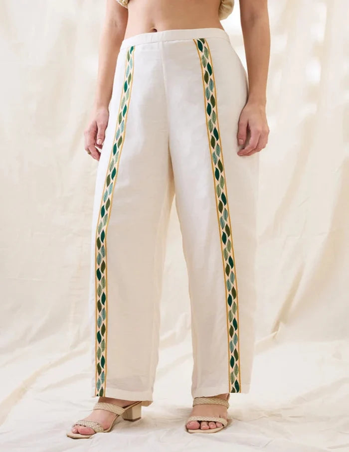White Gulzaar Appliquéd Peplum Top with front tie-ups paired with straight linen pants, offering an elegant and refined contemporary silhouette.