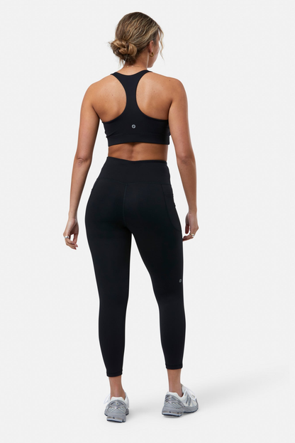 Woman wearing Gym+Coffee Relentless Bra Black, shown from back, featuring activewear by Gym+Coffee, shop at Dotique.