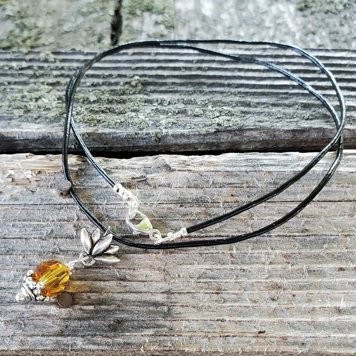 Handmade silver crystal pineapple leather necklace featuring a yellow Swarovski crystal pendant on a black cord.