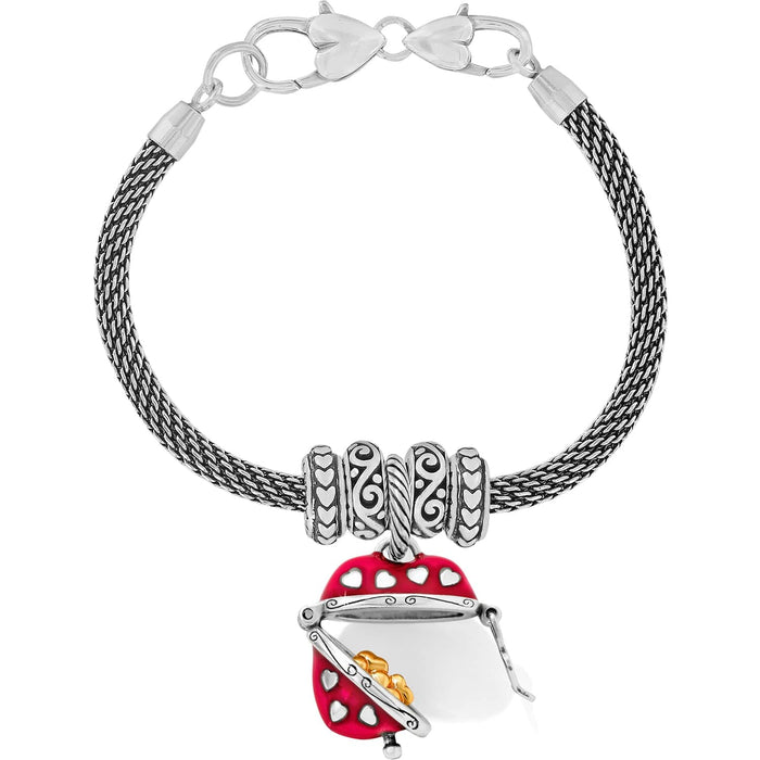 Brighton charm bracelet with silver-plated mesh chain, patterned spacers, and red enamel handbag charm on a white background
