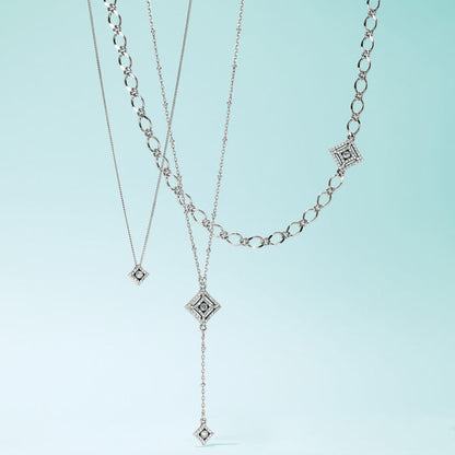 Brighton layered necklaces with silver-plated diamond-shaped pendants featuring crystal accents and varied chain styles on a white background
