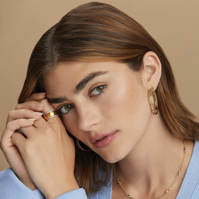 Model wearing Brighton gold-plated hoop earrings with hammered texture and coordinating Brighton ring and necklace accessories
