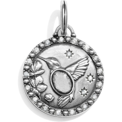 Brighton silver-plated charm pendant with hummingbird, flowers, stars, and crystal-accented border on a white background