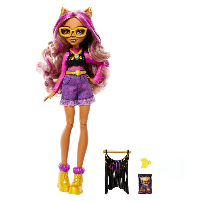 The Mattel Monster High Day Out Doll Clawdeen features long wavy pink and blond hair, yellow cat ears and glasses, a purple and black outfit, yellow shoes, plus accessories: a black fringe bag, crescent moon, and bag of chips.