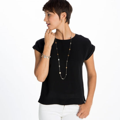 Model wearing a Brighton long station necklace with mixed silver and gold-tone discs, paired with coordinating bracelets
