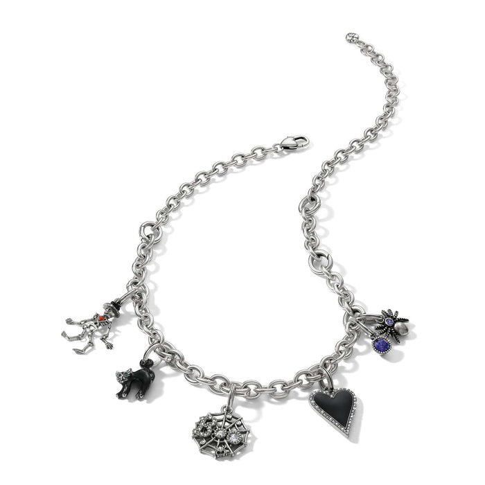 Brighton charm necklace with silver-plated chain, skeleton, black enamel cat, spiderweb, spider, and heart charms on a white background