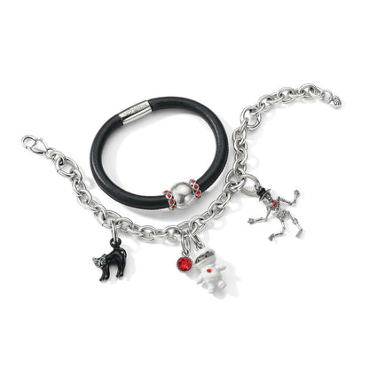 Brighton bracelets styled with Halloween enamel charms including black cat, mummy, and skeleton on a white background