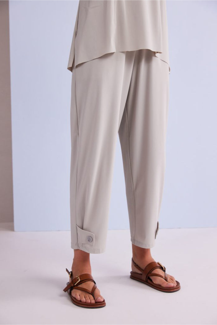 Model wearing Naya NPA26179 Slim Leg Trouser With Tab At Hem Ash in light ash color paired with brown sandals, shop Naya at Dotique.