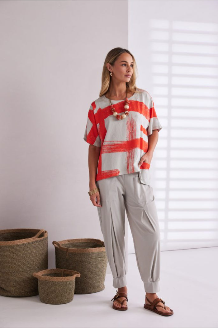 Model wearing Naya NPA26179 Slim Leg Trouser With Tab At Hem Ash paired with a casual patterned top and brown sandals, shop Naya at Dotique.