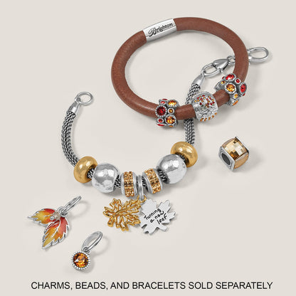 Brighton two-tone charm bracelets styled with crystal beads and leaf charms on a neutral background