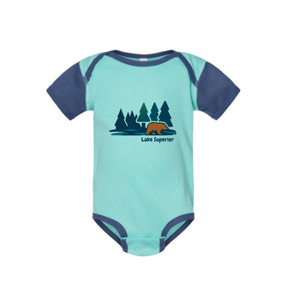 AdventureUs Lake Superior graphic featuring a bear in the woods on a two tone blue baby bodysuit.
