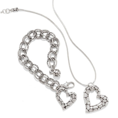 Brighton silver-plated heart pendant necklace styled with matching link bracelet featuring pebbled texture on white background