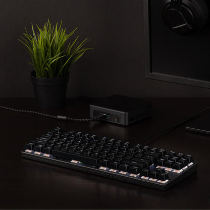 Plugable USB-MECH87RW tenkeyless mechanical keyboard connected to a computer via USB cable on a desk.