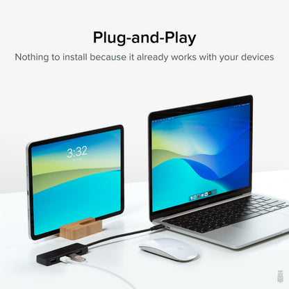 Plugable USBC-HUB4A 4-port USB 3.0 hub connected to a laptop and tablet, demonstrating plug-and-play compatibility.