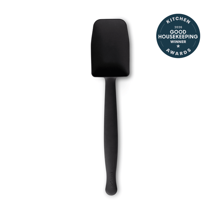 The Premiere Silicone Deep Sauté Spoon in black, featuring a flat head and dishwasher-safe design, is displayed on a white background. A circular badge at the upper right reads "2024 Good Housekeeping Kitchen Awards Winner.