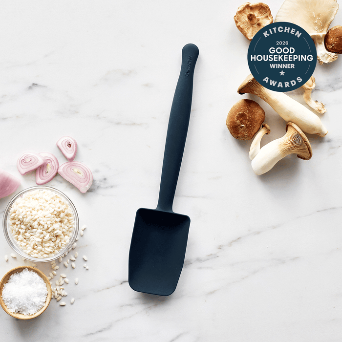 Blue silicone sauté spoon on marble, surrounded by mushrooms, shallots, rice, salt, and a 2023 award badge.