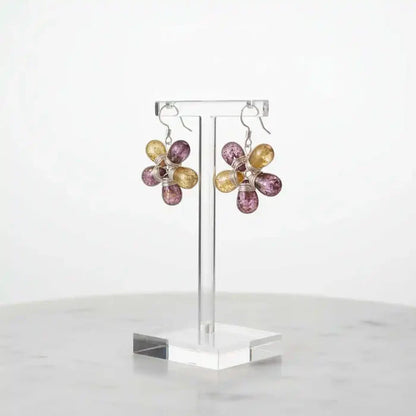 Purple and Yellow Flower Sterling Silver Earrings displayed on a stand, showcasing their floral design and colorful glass beads.