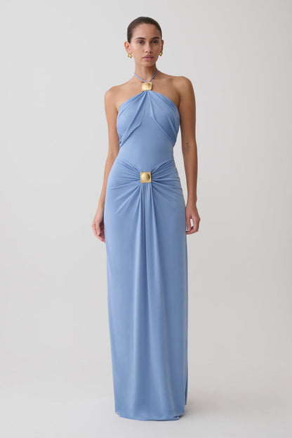 Woman wearing a blue halter maxi dress with hardware.