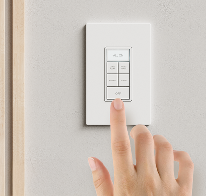 A hand pressing a button on a lighting keypad