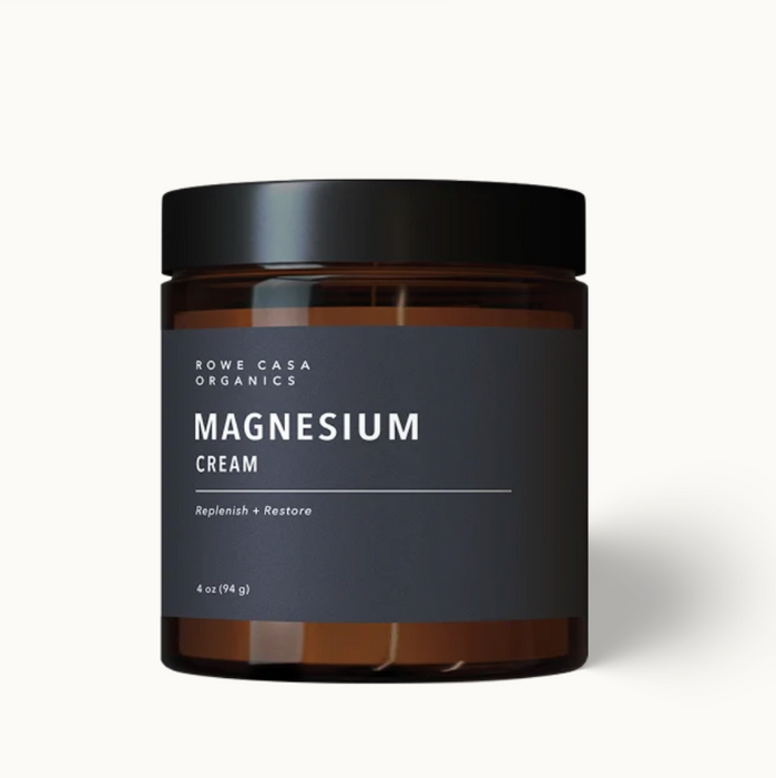 A 4 oz amber glass jar of Rowe Casa Organics Magnesium Cream with a black lid and dark gray label, set against a clean off-white background.