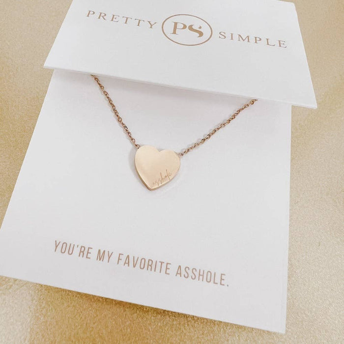 Rose gold heart-shaped necklace on a 'Pretty Simple' card with humorous text.